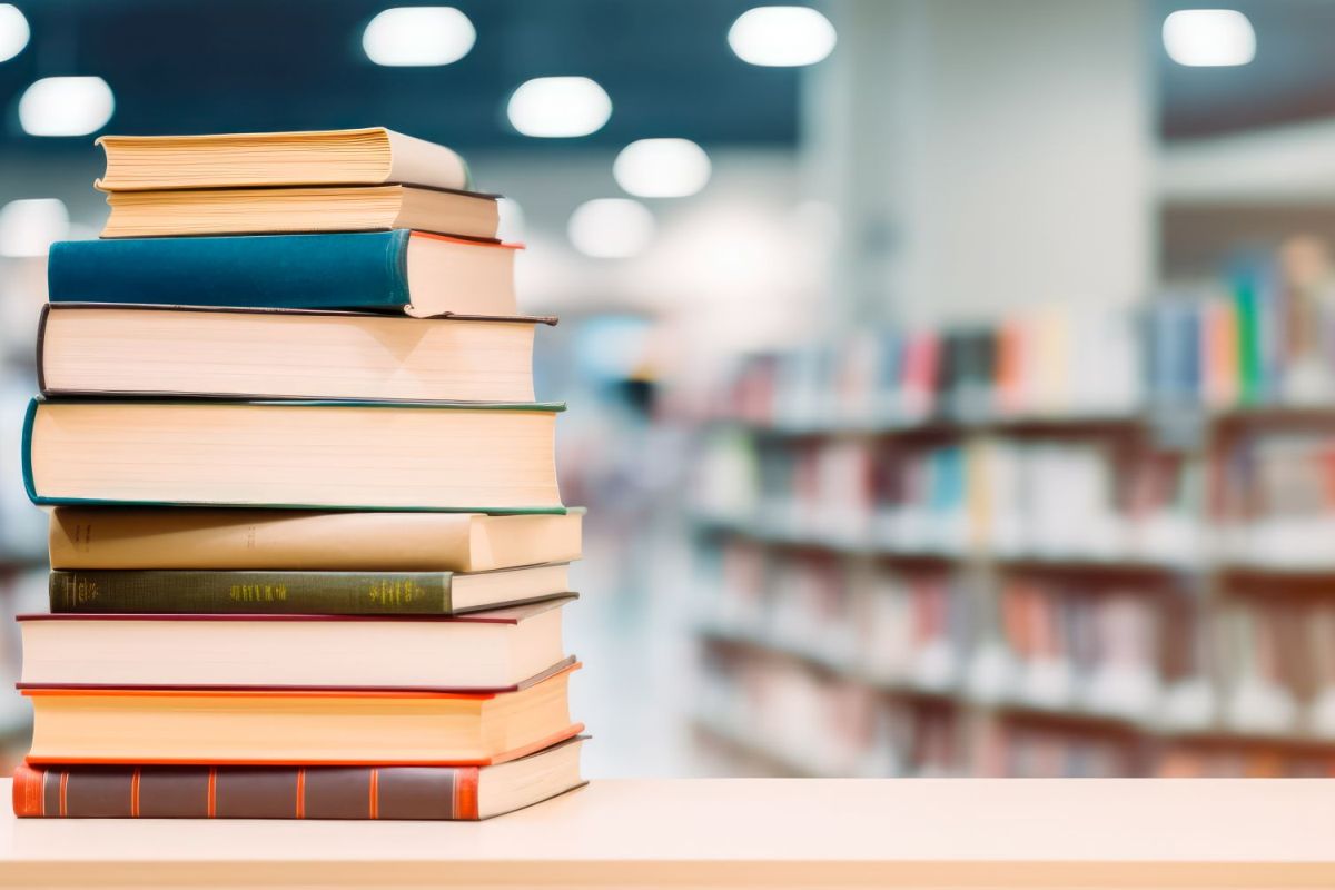 Bücher Ein Bücherstapel vor langer Regalreihe