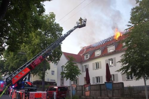 Dachstuhlbrand in der Kita Hirschlandstraße, davor steht ein Feuerwehrfahrzeug mit Drehleiter