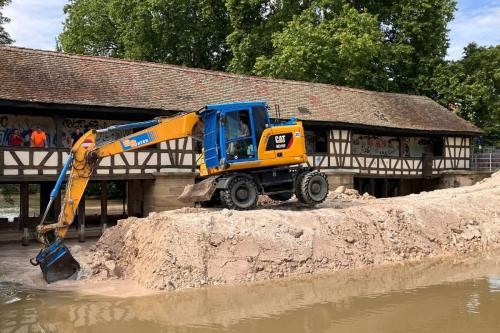 Bagger auf dem Damm vor dem Wasserhaus