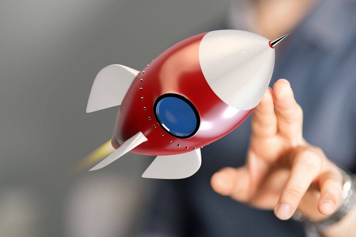 Rakete Person zeigt auf kleine rote startende Rakete.