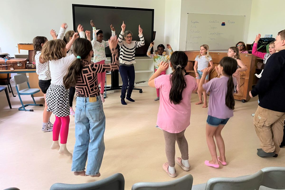 Im Kreis springende Kinder in einem Klassenzimmer