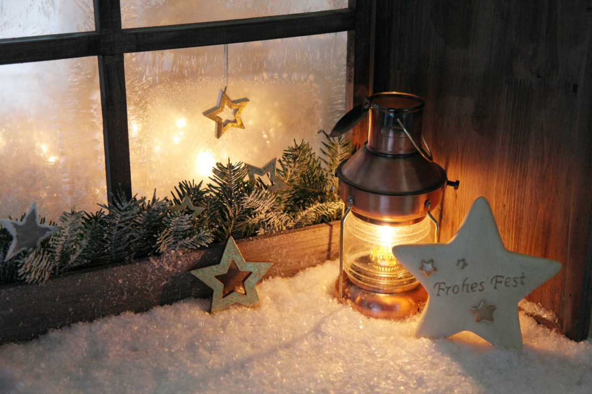 Weihnachtliches Fenster mit Laterne und Sternen im Schnee