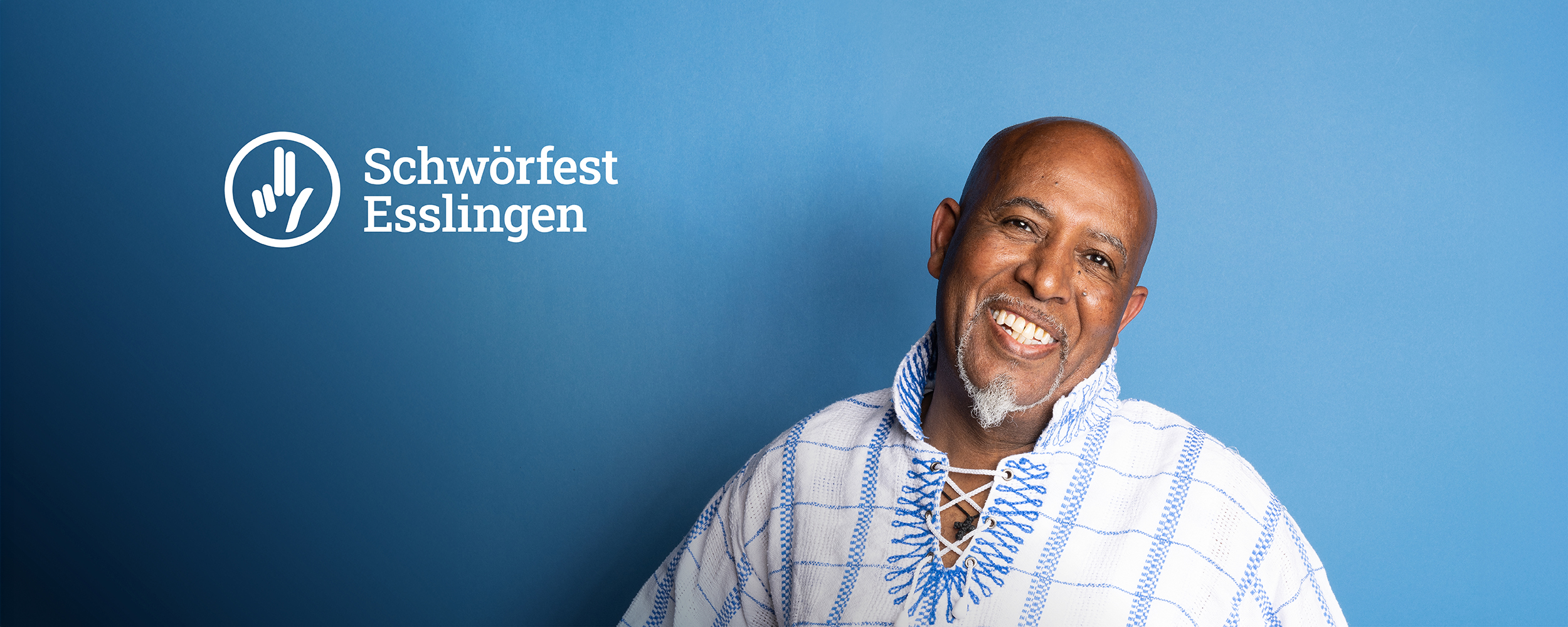 Ermias Mann lacht fröhlich in die Kamera
