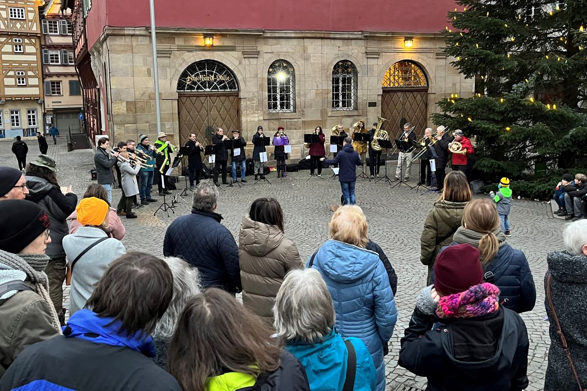 Posaunenchor und Publikum im Freien unter einem Tannenbaum