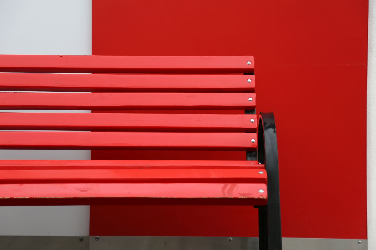 Rote Bank Eine rote Sitzbank vor einer weiß-roten Mauer