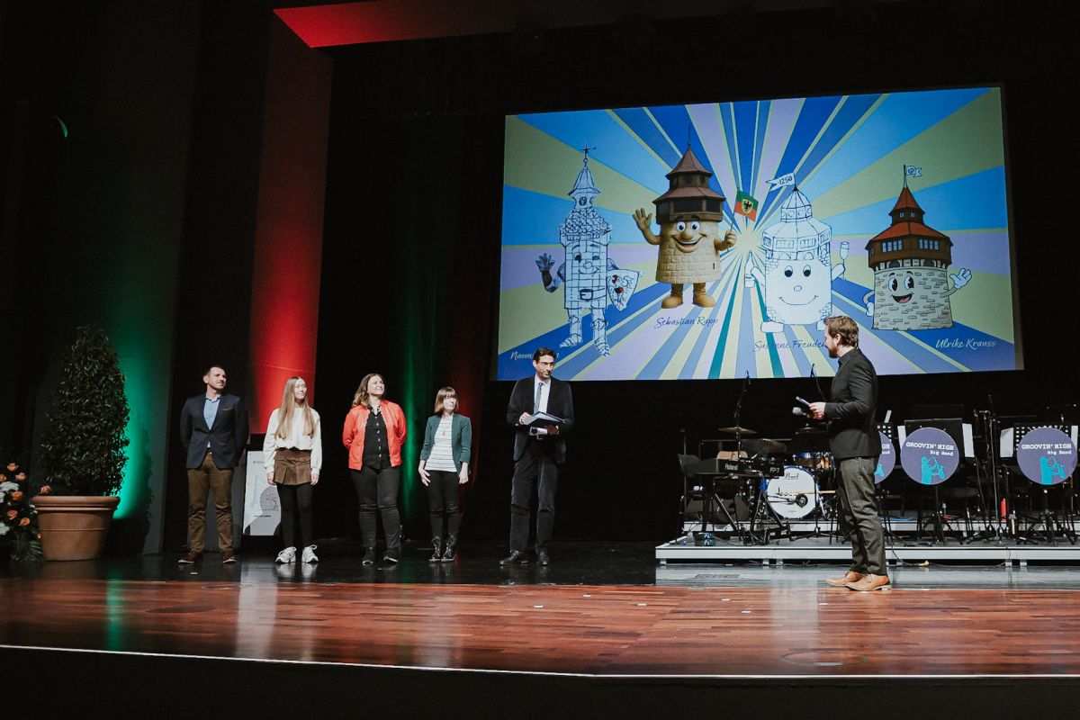 Das das Jubiläumsmaskottchen wird enthüllt.