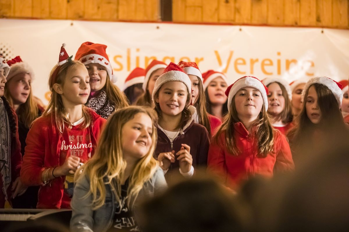 Kinder mit Nikolausmützen singen auf der Bühne 