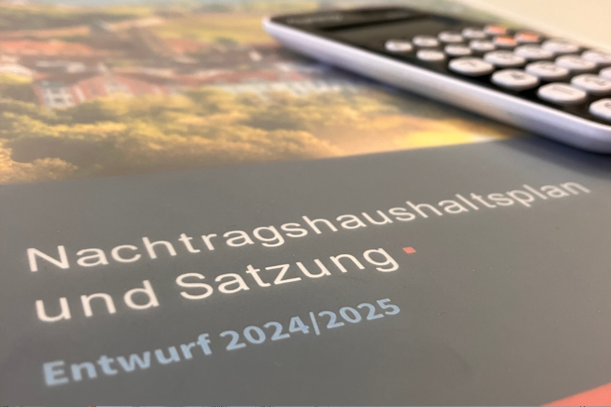 Zu sehen ist ein Blatt, auf dem "Nachtragshaushaltsplan und Satzung. Entwurf 2024/2025" steht