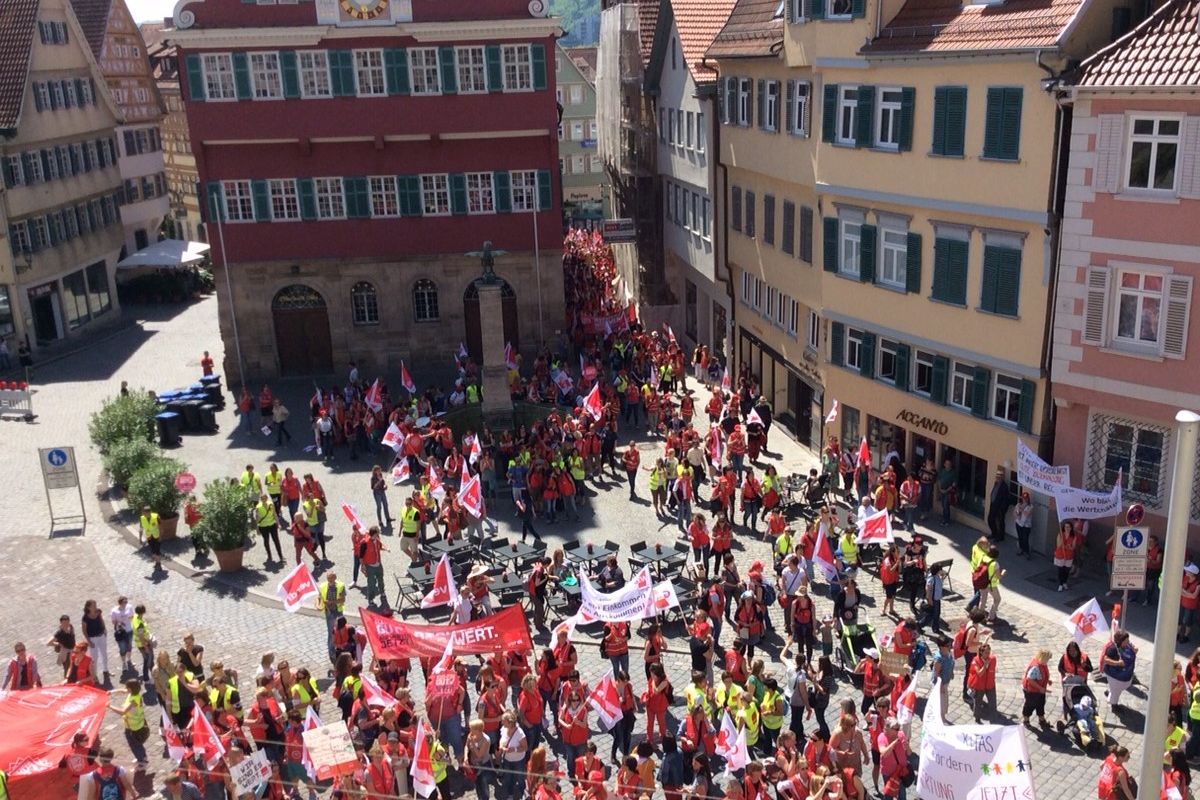 Versammlung von Menschen mit Fahnen auf dem Rathausplatz.