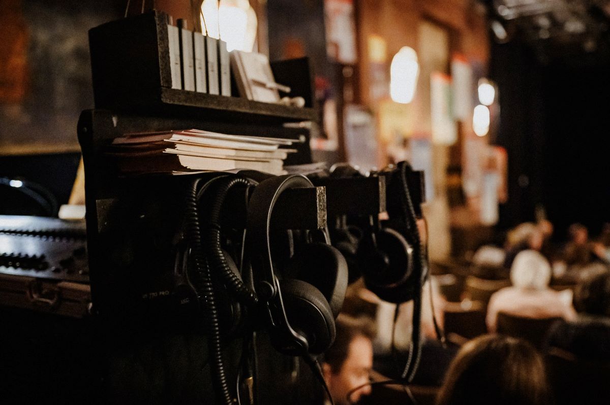 Kopfhörer hängen an einem Technikpult in einem Theatersaal