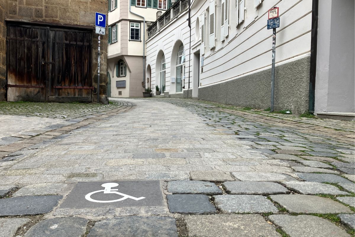 Ein barrierefreier Streifen auf dem historischen Kopfsteinpflaster in der Webergasse